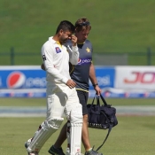 Ahmed Shehzad going off the field in pain after taken a blow on his helmet