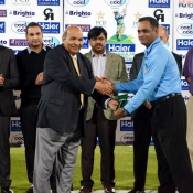 Umpire Tahir Shah receives his medal from Intikhab Alam in the final