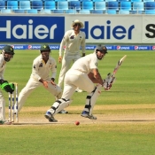 Mitchell Johnson flicks the ball on the final day of the 1st Test at Dubai