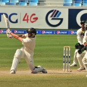 Mitchell Johnson plays a slog sweep on the final day of the 1st Test at Dubai