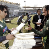 Misbah-ul-Haq signing a bat during practice session